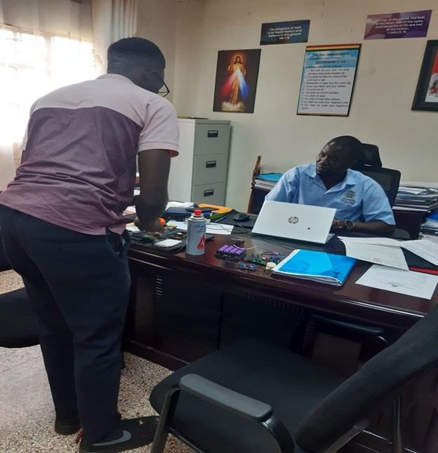 Mr. Obbo explaining the mechanism of action of his innovation to the Dean, Faculty of Engineering- Dr. Charles Onyutha