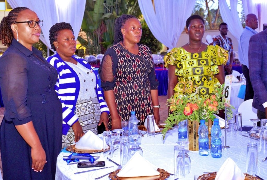 Participants standing in unity to sing the anthems during the alumni dinner.