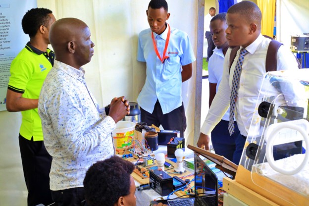Mr. Fredrick Kadulu interacting with visitors at the Kyambogo University booth