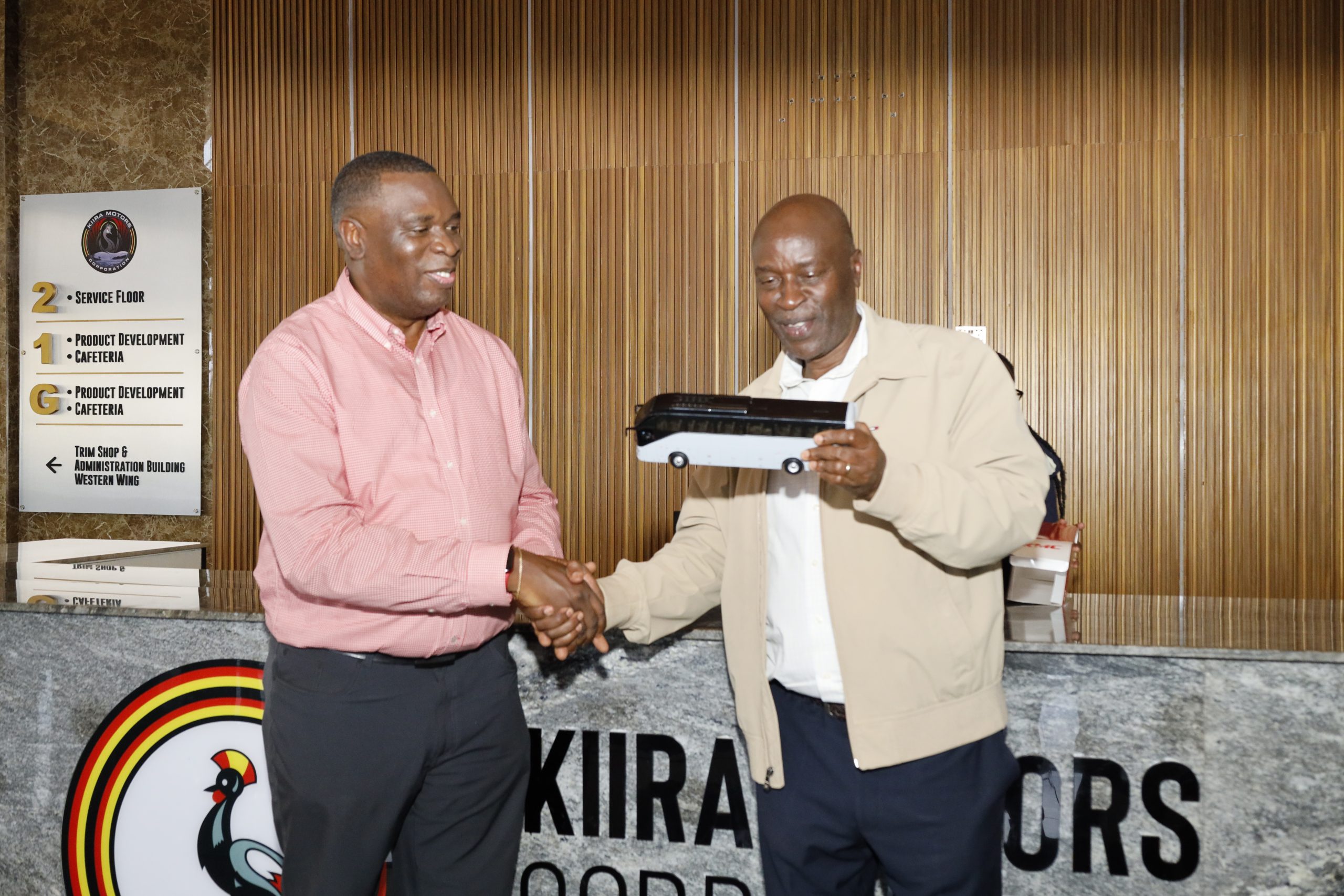 The Vice Chancellor receives a bus model from the CEO Kiira Motors