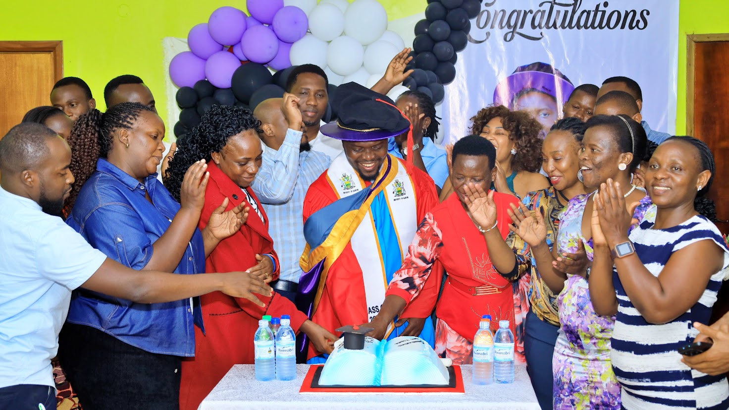 Dr. Kiganda Ivan cutting his graduation cake during the celebration at NOMA House, Kyambogo University.