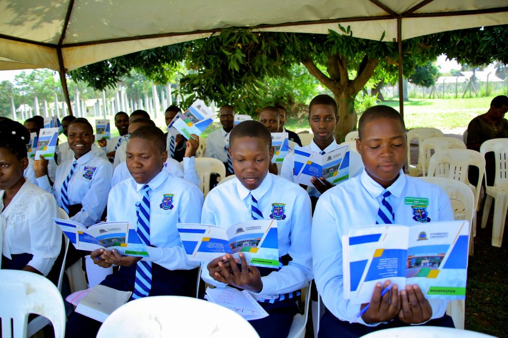 Students looking through the Kyambogo University prospectus for the courses